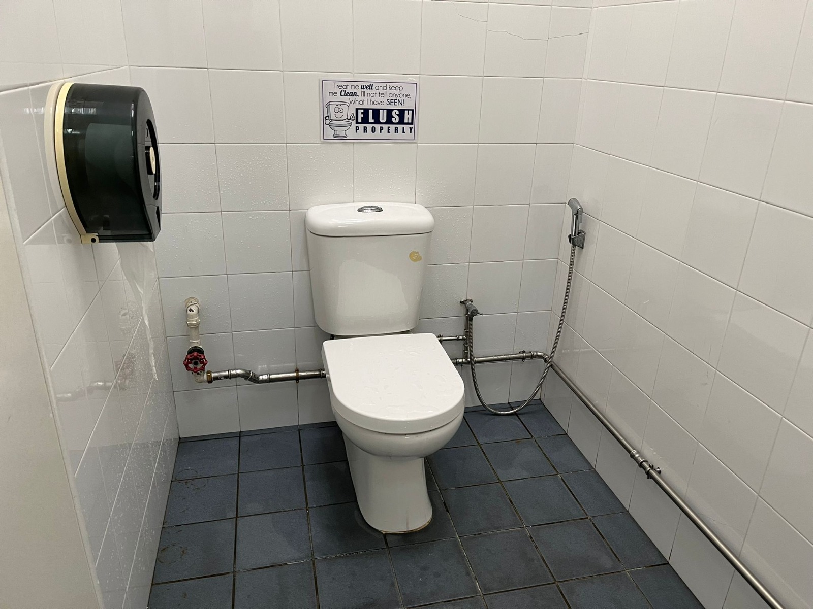 Exposed and rerouted water supply pipework in a tiled toilet after concealed pipe leak repair