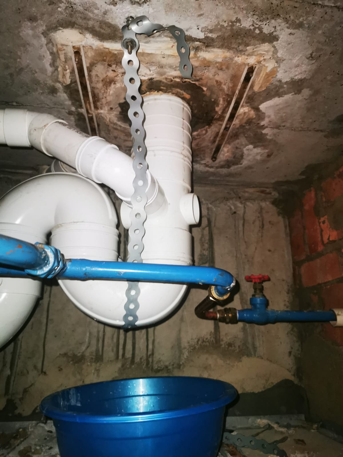 Damp concrete surface with staining around an active crack before PU injection repair