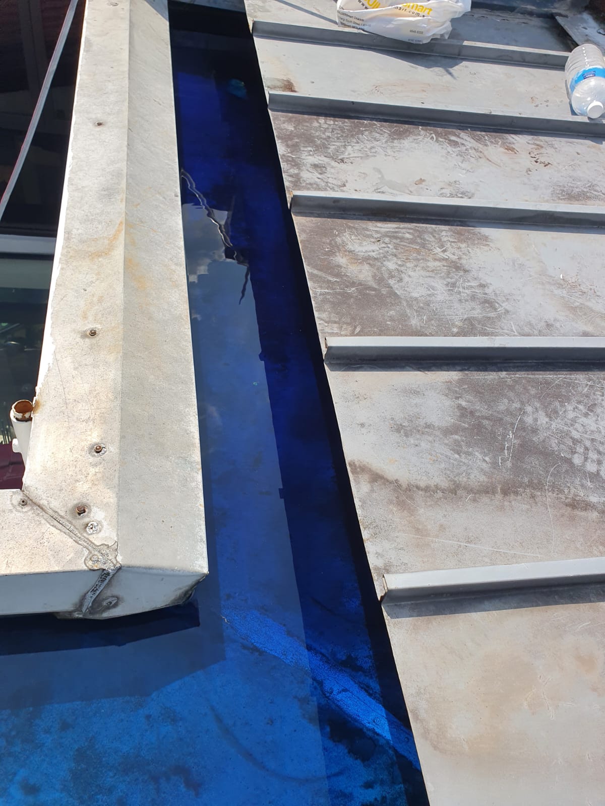 Dyed water ponded across a wet area floor during a 24-hour waterproofing test