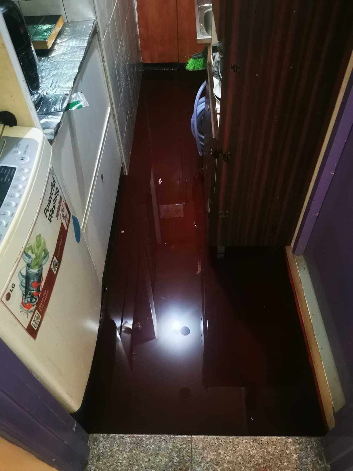 Coloured tracer dye spread across ponded water on a floor slab during leak testing